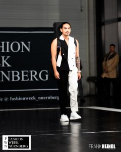 Carlos (The Voice of Germany TVOG) in schwarz-weißer Weste (britischer Stil) auf dem Laufsteg der Fashionweek Nürnberg seitliche Ansicht - LikeMan Maßanzüge Nürnberg