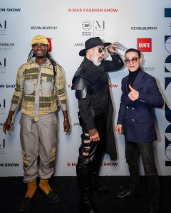 Morteza Faizi Designer auf der X-Mas Fashionweek München vor der Wand - LikeMan Maßanzüge Nürnberg