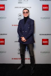 Morteza Faizi Designer auf der X-Mas Fashionweek München vor der Wand mit Blick in die Kamera- LikeMan Maßanzüge Nürnberg