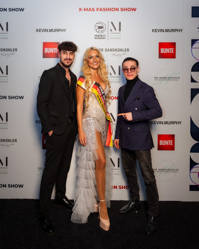 Morteza Faizi Designer auf der X-Mas Fashionweek München vor der Wand mit Monika Leiterin der Fashionweek - LikeMan Maßanzüge Nürnberg